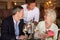 Waiter Serving Wine To Senior Couple In Restaurant