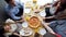 Waiter sets on the table a pizza to young friends enjoying a dinner in restaurant