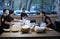 Waiter and waitress communicate while preparing fast food meals on a kitchen table of a restaurant