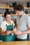 Waiter and waitress discussing over digital tablet