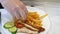 Waiter wearing gloves puts plate of fries close up