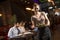 Waiter woman serving group of friends with food in the restaurant