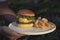 Waiters carrying dish beef burger and french fries with sunlight at restaurant