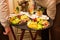 Waiters carrying tray with plates with fruits and vegetables on some festive event