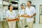 Waiters and waitress team smiling with trays full of dishes in the kitchen