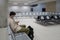 Waiting for flight at empty airport in Cyprus. Man sitting on chair with social distance marker at empty Paphos terminal