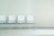 Waiting hall chairs forming a row against a white wall background