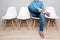 Waiting. Relaxing young man holding legs and sitting on chair