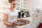 Waitress arranging cake at display cabinet