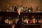 Waitress and bar shelves full of alcoholic beverages bottles