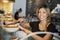 Waitress Behind Counter In Coffee Shop Cutting Slice Of Cake