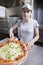 Waitress with cap serving a slice of all dressed p