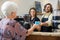 Waitress With Colleague Serving Coffee To Woman At