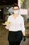 Waitress with face mask looks smiling at camera serving a plate of food