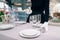 Waitress in gloves puts tableware, table setting