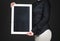 Waitress holding empty chalkboard. Young professional woman in black shirt.