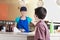 Waitress Looking At Customer At Counter In Ice Cream Parlor