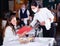 Waitress in protective mask helping woman in choosing meals from menu