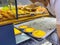 Waitress putting fresh-baked egg tarts into showcase of the bakeshop