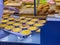Waitress putting pile of fresh-baked egg tarts onto showcase shelf