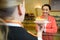 Waitress serving cake to customer in cafï¿½