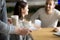 Waitress serving cappuccino and latte to couple in cafe, closeup