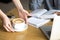 Waitress serving cappuccino to cafeteria visitor at cafe table,