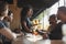 Waitress Serving Drinks To Group Of Male Friends Meeting In Sports Bar