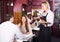 Waitress serving meal for young couple at table