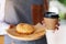 A waitress serving a piece of homemade donut in wooden tray and a paper cup of coffee