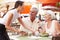 Waitress Serving Senior Couple Lunch In Outdoor Restaurant