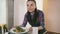 A waitress takes a dish on a white plate from the kitchen of the restaurant