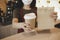 Waitress wearing protection face holding hot coffee cup and paper bag waiting for customer