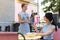 Waitress wearing striped apron receiving bank card from client
