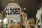 Waitress woman wearing protection face mask turning open sign board on glass door