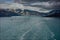 The wake of a cruise ship sailing away from Hubbard Glacier with a view of the glacier and mountains