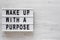 `Wake up with a purpose` words on a lightbox on a white wooden background, top view. Overhead, from above, flat lay. Copy space