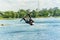 Wakeboarder jumps from a springboard behind a rope and makes a wave on the water