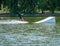 Wakeboarder surfing on Mogosoaia Lake preparing to make a jump