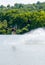 Wakeboarder on the wakeboard in a jump on a background of cloudy sky and forest