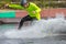 Wakeboarder on wakeboard landed in water surrounded by splash. Wakeboarding is an extreme sport