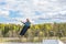 Wakeboarding. Teen Wakeboarder makes extreme Jump in air on wakeboard. Girl flies in the sky