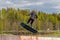 Wakeboarding. Teen Wakeboarder makes extremely difficult jump in air on wakeboard. Girl flies in the sky