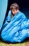 Waking up to a fresh new day...camping rocks. Portrait of a young boy wrapped in his sleeping bag.