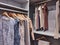 Walk in closet with clothes hanging and shoes on shelving