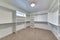 Walk in closet of house with empty built in shelves and two levels clothing rods