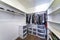 Walk-in closet with plastic wardrobe storage and wall mounted shelves and rods