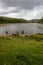 A walker looking across Derwent reservoir towards Howden Dam