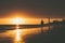 Walker on seashore with lighthouse during sunset in Maspalomas