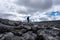 Walker silhouette on rock field on Scottish Highland Munro